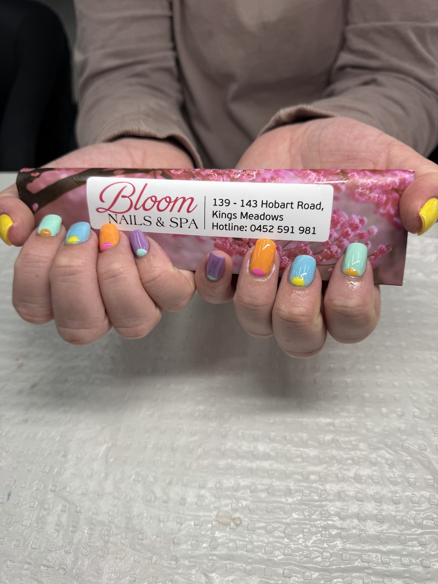Mixed pastel nails, each finger a different colour